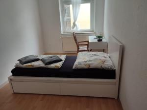 Cama en habitación con ventana y silla en Cozy spacious room near Halle Hbf w/ iPad, Netflix & Wi-Fi, en Halle an der Saale