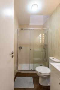 uma casa de banho com um chuveiro, um WC e um lavatório. em Hostel & cia no Porto