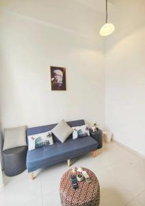 - un salon avec un canapé bleu et un tabouret dans l'établissement Centralize Stylish Loft Apartment Beside Mrt 摩登小屋, à Singapour