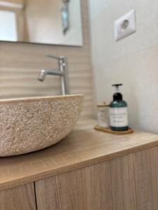 un lavandino in bagno con una bottiglia di sapone su un bancone di Strettomare-Business & travel apartment a Reggio di Calabria