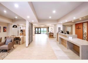 an office lobby with a reception desk and a dining area at Candlewood Suites Detroit Sterling Heights by IHG in Waldenburg
