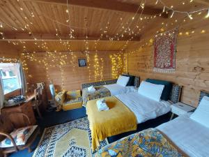 1 dormitorio con 2 camas en una cabaña de madera en Pilgrims of the Goddess, en Glastonbury