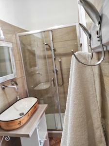 ein Bad mit einer Glasdusche, einem Waschbecken und einem WC in der Unterkunft TIK TAK B&B diffuso in Verbicaro