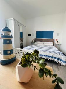 1 dormitorio con 1 cama y un faro azul y blanco en La Vigna Di Circe, en San Felice Circeo