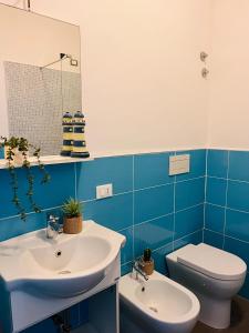 Baño azul con lavabo y aseo en La Vigna Di Circe, en San Felice Circeo