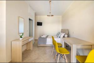 sypialnia z łóżkiem, biurkiem i żółtymi krzesłami w obiekcie Villa Dimitra - Amazing sea view w mieście Poros