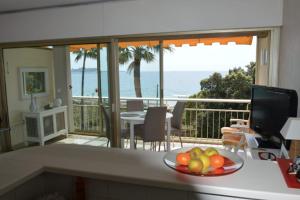a kitchen with a bowl of fruit on a counter at Cozy cocoon with balcony close to the sea in Cannes