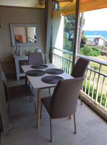 a table and chairs in a room with a balcony at Cozy cocoon with balcony close to the sea in Cannes