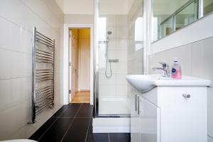 a bathroom with a sink and a shower at Paddington Modern Apartments in London