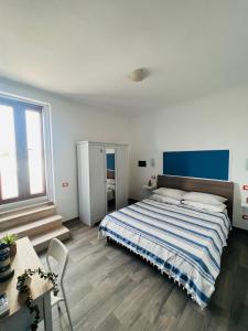 1 dormitorio con 1 cama grande y cabecero azul en La Vigna Di Circe, en San Felice Circeo