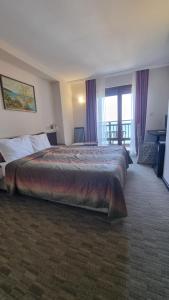 a hotel room with a large bed and a balcony at hotel DIAMANTI in Sozopol