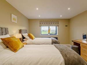 a bedroom with two beds and a window at 4 Bed in Shap 89957 in Shap