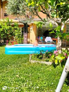 um homem numa piscina insuflável azul num quintal em Al focolare di Enzo em Marino