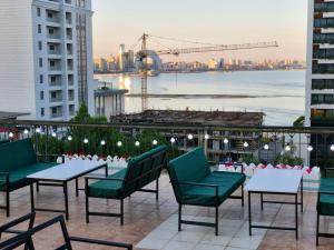 a patio with tables and chairs and a view of the city at Nur Hotel Sea View in Baku