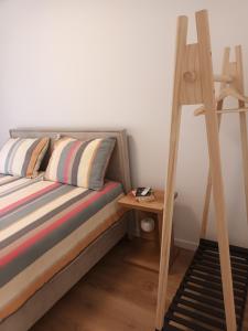 a bed with a wooden ladder next to a side table at DREAMS APARTMENT KAŠTELA in Kaštela