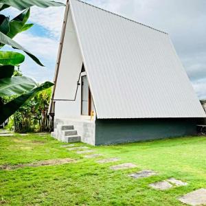 a small white house with a white roof at Volcano White Glamping in Kubupenlokan +4 photos