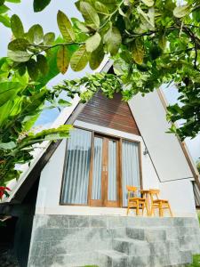 a house with two chairs in front of it at Volcano White Glamping in Kubupenlokan