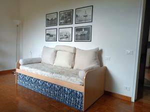 un sofá en una sala de estar con fotos en la pared en Appartamento con giardino a Boccadasse en Génova