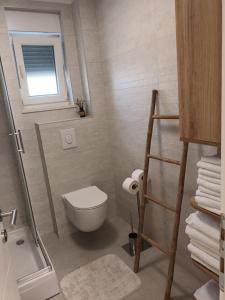 a small bathroom with a toilet and a window at DREAMS APARTMENT KAŠTELA in Kaštela