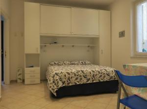 a bedroom with a bed with a cabinet above it at Appartamento L'ONDA - 3 in Fezzano