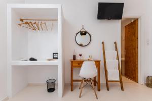 a white room with a desk and a chair at Naxos Beachwalk Rooms in Naxos Chora