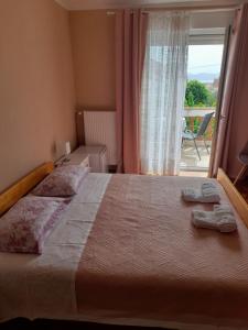 a bedroom with a large bed with a large window at Rooms Margarita in Zadar