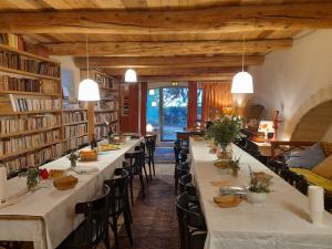 une salle à manger avec de longues tables dans une bibliothèque dans l'établissement Le Mas du Lac, à Uzès