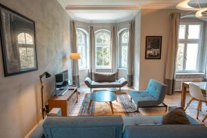緬濟古熱的住宿－Villa Klara - Apartamenty Wakacyjne，客厅配有蓝色的沙发和电视