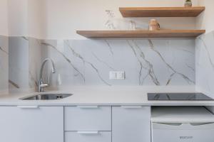 a kitchen with white cabinets and a sink at Veneto Sea View Apartments in Stalida +51 photos