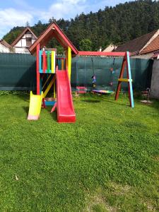 um parque infantil com equipamento de brincar num quintal em Casa Diana Rasnov em Rasnov