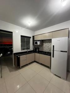 una cocina con nevera y microondas en Apartamento no último andar + vaga de garagem, en Cascavel
