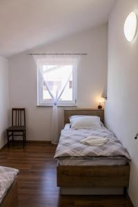a bedroom with a bed and a window at Apartmani Mladenka in Malinska