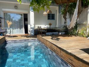 a swimming pool in a backyard with a table and chairs at Maison du bonheur in Lanton