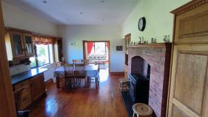 a kitchen and dining room with a brick fireplace at Swinford Country House in Swinford