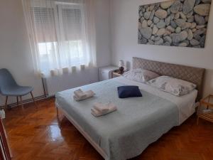 a bedroom with a bed with two towels on it at Rooms Margarita in Zadar