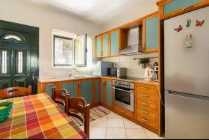 een keuken met een tafel en een koelkast bij Villa Dimitra - Amazing sea view in Póros