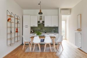a kitchen with a wooden table and white chairs at La Sismonda in Rimini