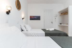 2 letti in una camera con pareti bianche di Naxos Beachwalk Rooms a Naxos Chora