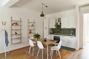 a kitchen with a wooden table and white cabinets at La Sismonda in Rimini