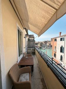 balcone con sedie, tavolo e vista sull'acqua di Foscari Palace a Venezia