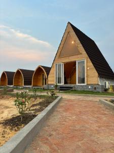 una casa de madera con techo de gambrel en Buru Resort, en Ghātsīla