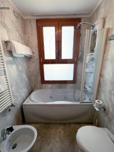 uma casa de banho com uma banheira, um WC e um lavatório. em Foscari Palace em Veneza