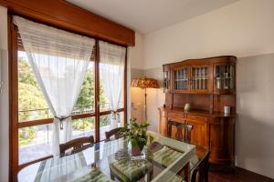 a dining room with a glass table and a window at Villa Gabri 1 e 2 in Arona