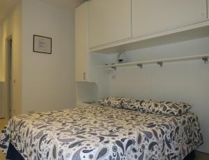 a bedroom with a bed with a black and white comforter at Appartamento L'ONDA 2 - via Provinciale in Fezzano