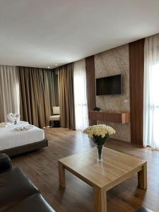 una habitación de hotel con un jarrón de flores sobre una mesa en Le Rio Appart-Hotel City Center en Tánger