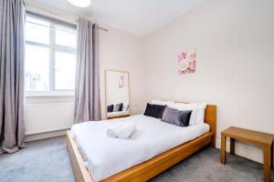 a bedroom with a bed and a window at Paddington Modern Apartments in London