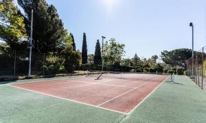 una pista de tenis con dos raquetas de tenis. en Appartement Location saisonnière Résidence ILE D'OR, en La Londe-les-Maures