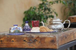 a table with a tea pot and a plate of food at Dar Nejma in Fez