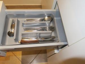 un cajón lleno de utensilios de plata en un armario en Appartamento L'ONDA 2 - via Provinciale en Fezzano