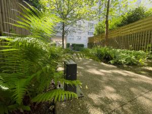 a garden with a fence and a plant with a speaker at Charmant appart près du métro et aux portes de Paris in Saint-Ouen